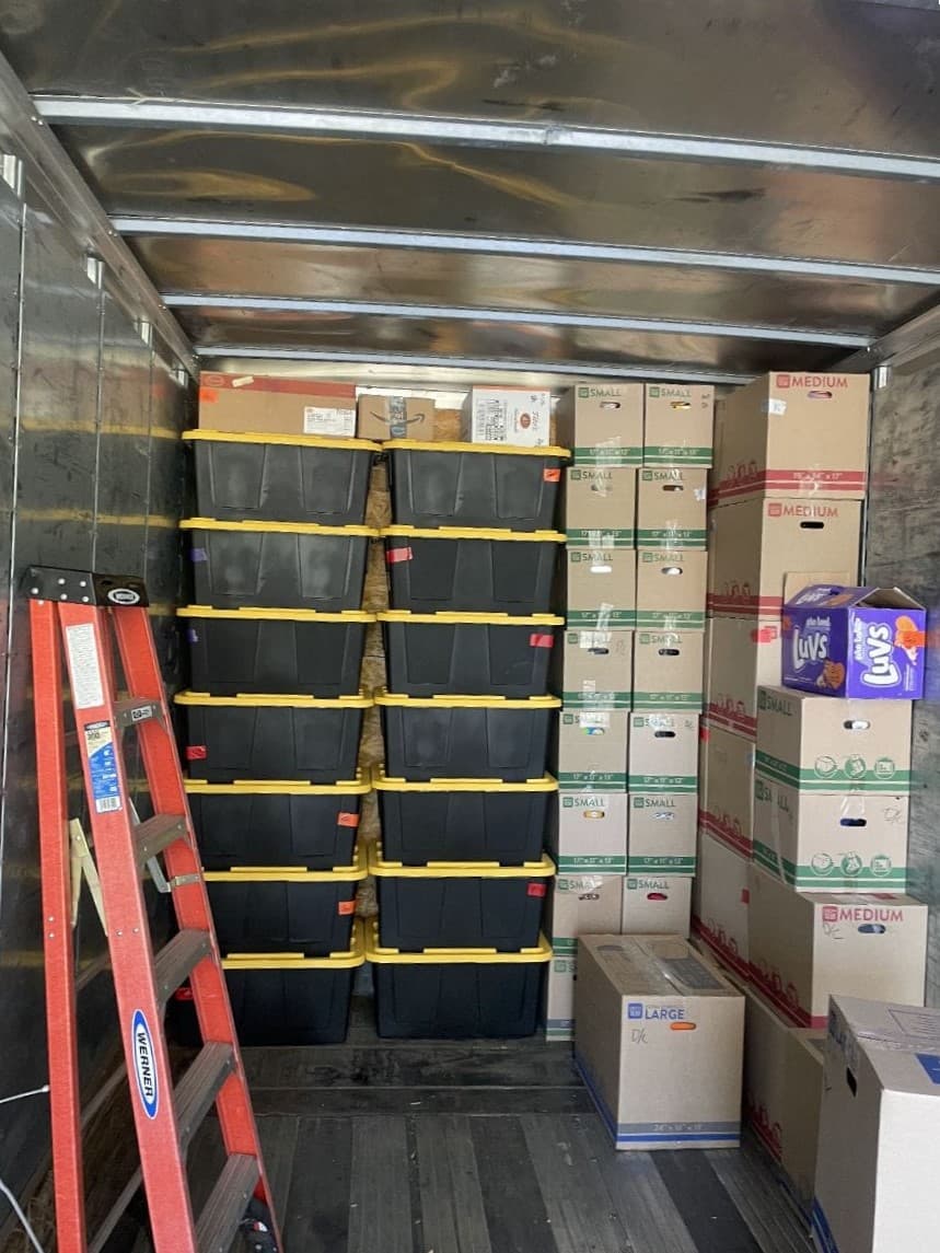 picture of a bunch of boxes stacked up in the back of a box truck ready to be moved to their new location